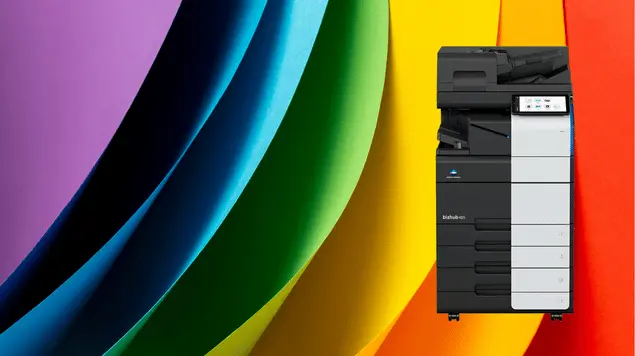 Photocopieur Konica Minolta Bizhub Couleur – Prix et Qualité au Maroc Photocopieur Konica Minolta couleur Bizhub devant un fond dégradé multicolore – Solution d'impression professionnelle haute qualité pour entreprises et centres de copies.